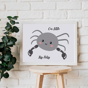 Pode incluir: Uma impressão emoldurada branca com uma aranha cinza com pegadas pretas nas pernas. O texto na impressão diz "Our Little Itsy Bitsy".