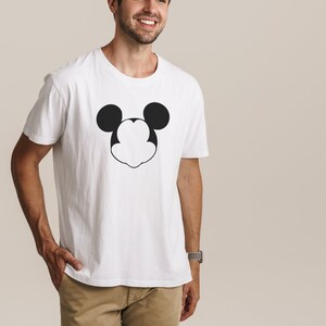 以下が含まれることがあります： 白地に黒と白のミッキーマウスの顔のグラフィックがプリントされたTシャツ