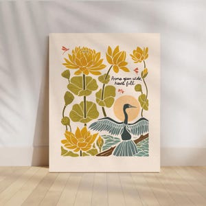 Peut inclure: Un fond beige avec une illustration jaune, verte et bleue d'un oiseau aux ailes déployées, entouré de fleurs jaunes et de feuilles vertes. Le texte "Arms open wide, heart full." est écrit en noir.