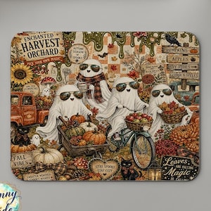 May include: A rectangular mouse pad featuring a whimsical autumn scene with four ghosts wearing sunglasses. The design includes a red truck, a bicycle with a basket of apples, pumpkins, sunflowers, and text reading Enchanted Harvest Orchard.