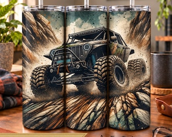 Puede incluir: Un vaso cilíndrico de metal con pajita que presenta un estampado gráfico de un vehículo todoterreno sobre terreno rocoso. El diseño incluye tonos tierra, paisajes montañosos y una ilustración detallada de un camión robusto.