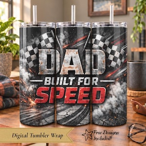 Könnte beinhalten: Ein zylindrischer Metallbecher mit Strohhalm, verziert mit einem schwarz-grauen Rennsport-Design, Zielflaggen, Reifenspuren und Rauch. Der Text DAD BUILT FOR SPEED ist in großen, abgenutzten weißen und kräftigen roten Buchstaben zu sehen.