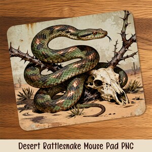 May include: Mouse mat with a desert rattlesnake coiled around a skull and thorny branches. The snake has green and brown scales. The background shows a desert landscape with cacti. The text "Desert Rattlesnake Mouse Pad PNG" is at the bottom.