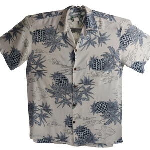 May include: A white short-sleeved button-down shirt with a blue and white pineapple and island map print.