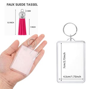 May include: A pink faux suede tassel with a silver cap and a rectangular clear acrylic keychain frame. The tassel measures 1.5 inches in total length with a 1 inch fringe. The keychain frame measures 2.75 inches by 1.75 inches with a metal ring.