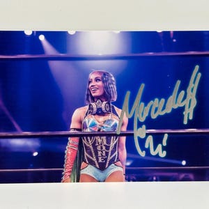 May include: A set of three ceramic mugs with a speckled, cream-colored glaze. Each mug features a different hand-painted floral design in shades of blue, green, and yellow. The mugs have a simple, rounded shape and a comfortable handle.