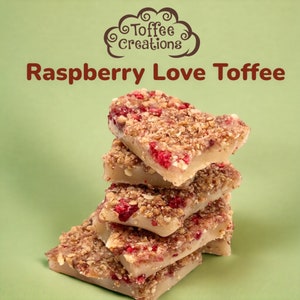 May include: A stack of raspberry toffee squares with a light-colored base and a crumbly topping. The toffee pieces have visible pieces of red raspberry. The image includes the text "Toffee Creations" and "Raspberry Love Toffee" on a green background.