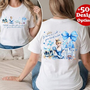 Puede incluir: Camiseta blanca con un dise&ntilde;o de Cenicienta. La parte delantera de la camiseta tiene un carruaje, Cenicienta y un gr&aacute;fico de castillo con el texto "Fill the world with sunshine your heart makes." La parte trasera tiene un gr&aacute;fico de Cenicienta y el texto "A dream is a wish your heart makes."