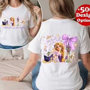Puede incluir: Camiseta blanca con un gr&aacute;fico colorido de una princesa, una torre y un caballo. El texto "At last I see the light" est&aacute; impreso. Tambi&eacute;n es visible un c&iacute;rculo rojo con "+500 Design Options". Dise&ntilde;o de cuento de hadas.