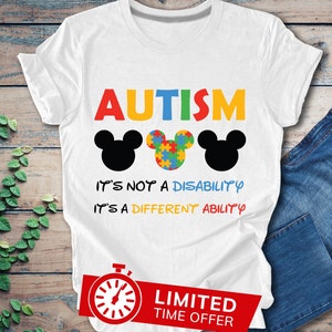 May include: White t-shirt with the word "AUTISM" in rainbow colors, three Mickey Mouse heads, two black and one with a puzzle piece pattern, and the text "It's not a disability, it's a different ability".