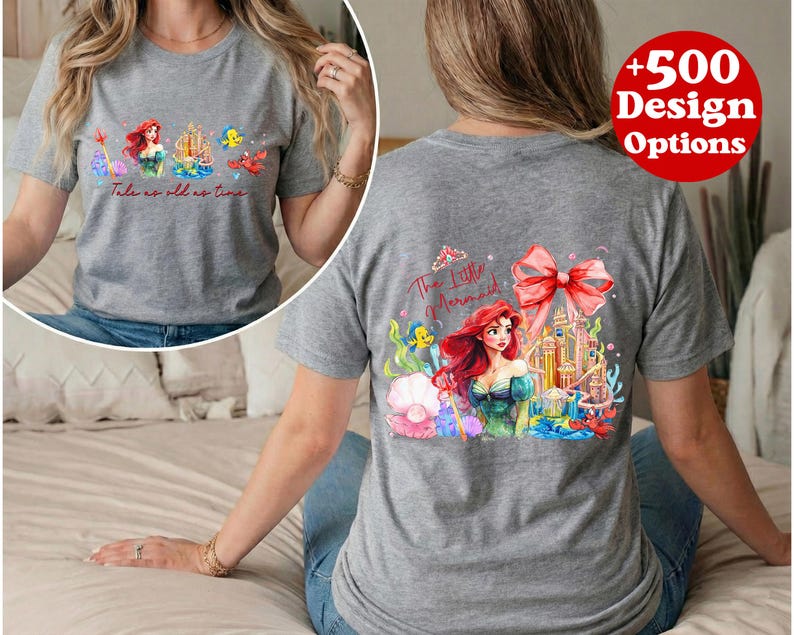 Puede incluir: Camiseta gris con una colorida ilustraci&oacute;n de Ariel de La Sirenita. La parte delantera de la camiseta tiene a Ariel y otros personajes con el texto "Tale as old as time". La parte trasera tiene un dise&ntilde;o m&aacute;s grande con Ariel, un castillo y un gran lazo.