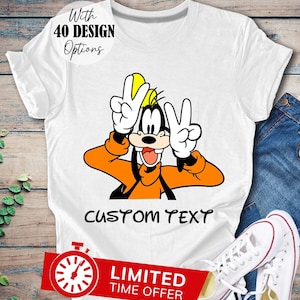 May include: White t-shirt featuring a cartoon image of Goofy giving the peace sign. The text "CUSTOM TEXT" is printed below the image.