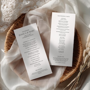 May include: Two white rectangular wedding program cards with black serif text. The left card lists the order of ceremony for Jessica and Marc at Havenbrook Estate. The right card lists the wedding party and a thank you message.