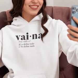 May include: White hooded sweatshirt with the text "vai na (bay-nah) s.f. 1. Lo define todo 2. No define nada" printed on the front.