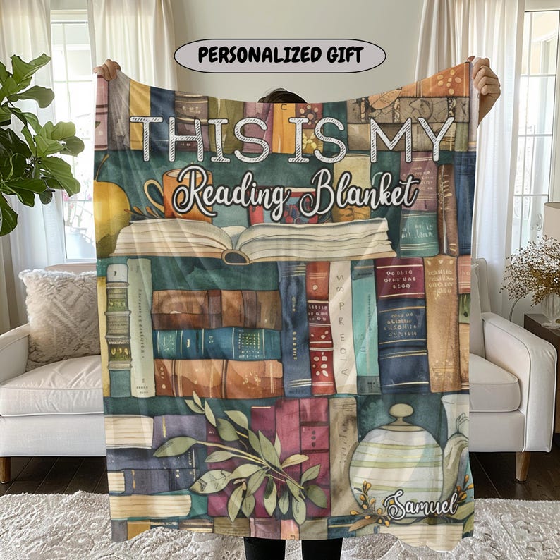 May include: A personalized reading blanket featuring a watercolor design of a bookshelf filled with books, a teacup, and a teapot. The blanket has the text "THIS IS MY Reading Blanket" and the name "Samuel".