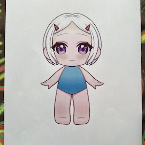 May include: A cartoon illustration of a doll with white hair, purple eyes, and a blue swimsuit. The doll has small red hair clips. The text "Paper Dolls By Mila" is printed at the bottom.