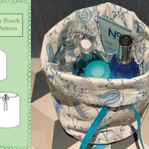 May include: A white toiletry pouch with a blue floral pattern and a turquoise drawstring. The pouch is filled with various toiletries, including a blue bottle of perfume, a clear bottle of lotion, and a blue and white container.