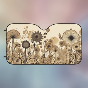 May include: A beige car sunshade with a black border featuring a floral design with butterflies. The flowers are in shades of brown and black.