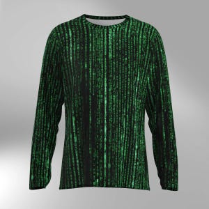 May include: Black long-sleeved shirt with a green digital rain pattern. The design features vertical lines of green characters on a black background, creating a tech-inspired aesthetic. The shirt has a crew neck and long sleeves, suitable for casual wear.