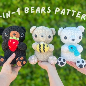 May include: Three crocheted bear plushies in black, tan, and white, each holding a different item: a strawberry, a bee, and a blue scarf. The text "3-IN-1 BEARS PATTERN" is above the bears.