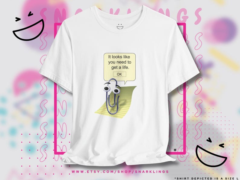 May include: White t-shirt with a graphic of a paperclip with eyes and a speech bubble that says "It looks like you need to get a life. OK."