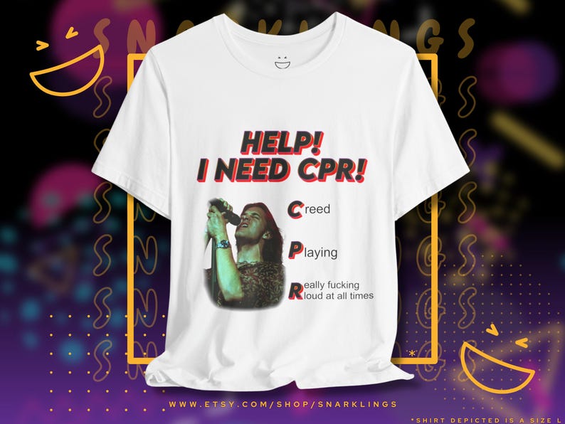May include: White t-shirt with a red and black graphic that says "HELP! I NEED CPR!" with the words "Creed", "Playing", and "Really fucking loud at all times" listed below. The graphic also features a black and white photo of a person singing into a microphone.