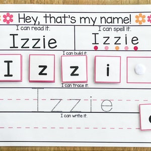 May include: A printable worksheet for learning to spell the name "Izzie". The worksheet includes sections for reading, spelling, building, tracing, and writing the name. The name is written in large letters at the top of the page, and there are smaller squares with individual letters for building and tracing. There are also dotted lines for tracing and writing the name.