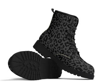 Pode incluir: Um par de botas de combate pretas e cinzentas com estampa de leopardo. As botas têm um design com atacadores, uma sola preta grossa e um padrão de leopardo cinzento. Uma bota está em pé e a outra está deitada de lado, mostrando a sola.