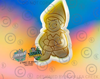 May include: A white plastic cookie cutter shaped like a seated elf wearing a pointed hat and a collared tunic. The design features a clear outline of the elf's face, body, and clothing details, with a smooth, raised edge for cutting dough.