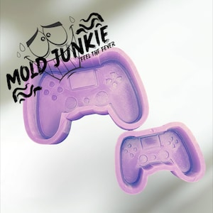 May include: Two purple silicone molds shaped like video game controllers. The molds are for making resin crafts.