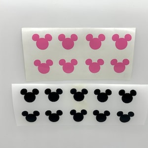 May include: Two sheets of white sticker paper with Mickey Mouse head silhouettes. One sheet has pink Mickey Mouse heads and the other sheet has black Mickey Mouse heads.