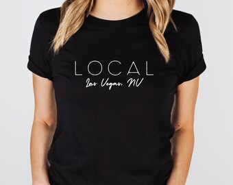 May include: A black t-shirt with white text that reads "LOCAL Las Vegas, NV".