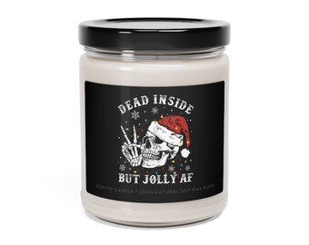 Könnte beinhalten: Ein weißes Kerzengefäß mit einem schwarzen Etikett, auf dem "Dead Inside But Jolly AF" steht. Das Etikett zeigt einen Schädel, der einen Weihnachtsmann-Hut trägt und ein Peace-Zeichen zeigt. Der Schädel ist von Weihnachtslichtern umgeben.