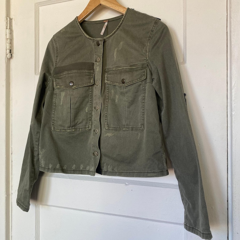 Chaqueta vaquera Free People con parches, color verde militar, botones, bolsillos y corte corto. imagen 1