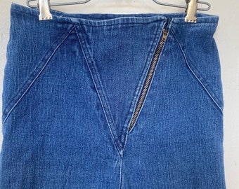 May include: A pair of blue denim pants with a zipper detail down the front. The pants have a high waist and a slim fit.