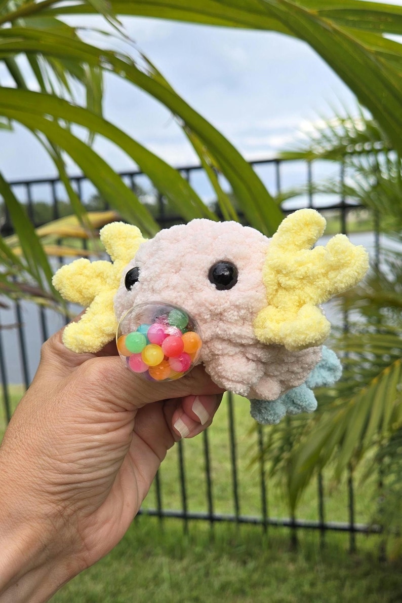 Fast, fun, cute crochet Axolotl. The pattern is clear and easy to follow. You need to know basic crochet and you will enjoy creating from this pattern. The finished toy is exciting to share because of the surprize of the stress ball popping out of its mouth. Not your ordinary Axolotl. Its a fidget toy too. Axolotl and a stress ball toy, a 2 in 1.