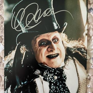 May include: A white ceramic mug with a black handle and the text "But First, Coffee" in a black, bold font. The mug is on a white surface.