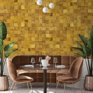 Könnte beinhalten: Eine braune, gepolsterte, gebogene Bank mit einem Glastisch und zwei braunen Samt-Stühlen mit goldenen Beinen. Der Tisch hat eine weiße Keramikvase mit getrockneten Blumen. Die Wand hinter den Möbeln ist mit einem Holzpaneelmuster verkleidet.