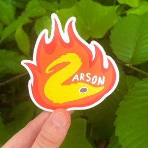 May include: A yellow cartoon eel on fire with the word "Arson" printed below it. The sticker is on a white background.