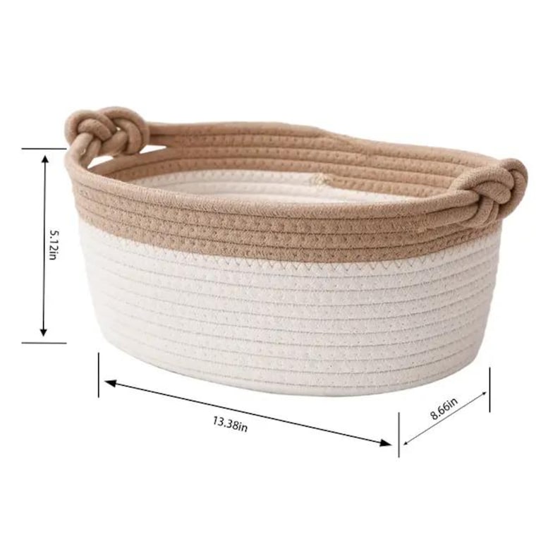 May include: A two-tone woven basket with a beige top and white bottom. The basket has two knotted handles and measures 13.38 inches long, 8.66 inches wide, and 5.12 inches high.
