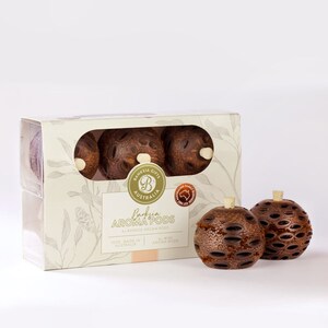 May include: A box of Banksia Aroma Pods, a natural air freshener made in Australia. The box features a brown and white design with the text "Banksia Gifts Australia" and "Banksia Aroma Pods". The box contains three brown Banksia pods.