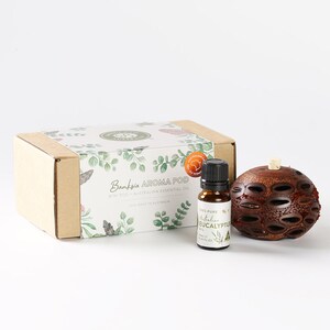 May include: A brown wooden Banksia aroma pod with a small bottle of 100% pure Australian Eucalyptus oil. The box is decorated with a floral design and the text "Banksia Aroma Pod" and "Mini Pod + Australian Essential Oil".