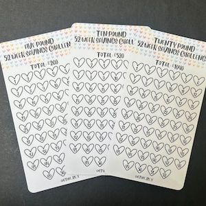 May include: Three white cards with heart-shaped boxes numbered 1-52 for a 52-week savings challenge. The cards are labeled "Five Pound", "Ten Pound", and "Twenty Pound" with the total savings amount. The top of each card has a colorful heart pattern.