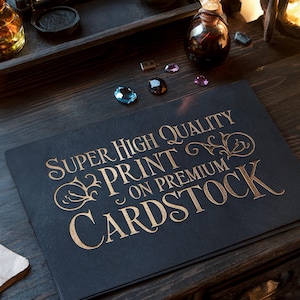 May include: A stack of black cardstock with gold lettering that reads "SUPER HIGH QUALITY PRINT ON PREMIUM CARDSTOCK." Several gemstones and small glass bottles are arranged on a dark wooden surface.