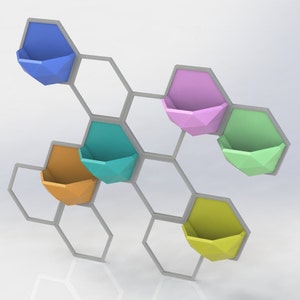 Peut inclure: Un organisateur mural hexagonal avec six jardinières géométriques colorées. Les jardinières sont dans des tons de bleu, rose, vert, orange et jaune.