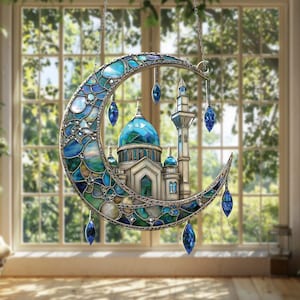 May include: A decorative stained glass crescent moon with a mosque design. The moon is crafted from blue and green glass, framed in silver. The mosque features a blue dome and minarets, with hanging blue crystal pendants.