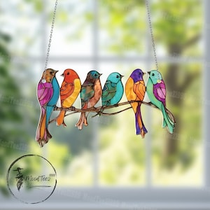 May include: A stained glass suncatcher featuring six colourful birds perched on a branch. The birds are painted in shades of blue, green, purple, orange, and yellow.