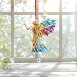 Può includere: Ornamento decorativo a forma di angelo con ali colorate in stile vetrata e un abito fluente. L'angelo è sospeso da un nastro rosso e ha un pendente di cristallo. L'angelo è rivolto verso l'alto, con un'espressione serena.
