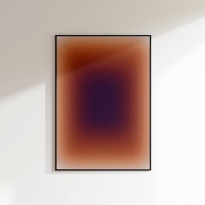 May include: A framed abstract art print with a gradient of brown, orange, and purple colors. The colors blend together to create a soft, ethereal effect.