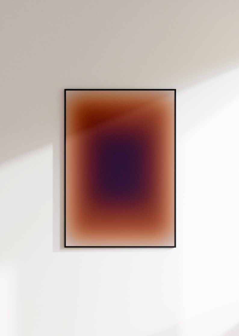May include: A framed abstract art print with a gradient of brown, orange, and purple colors. The colors blend together to create a soft, ethereal effect.